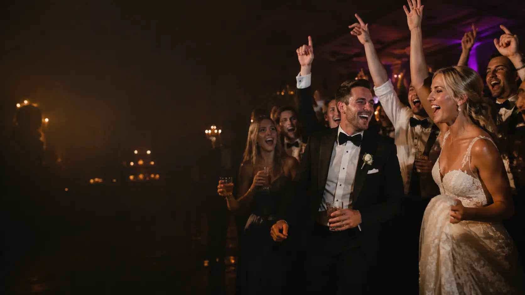 A bride, groom and friends sharing an energetic moment on the dancefloor